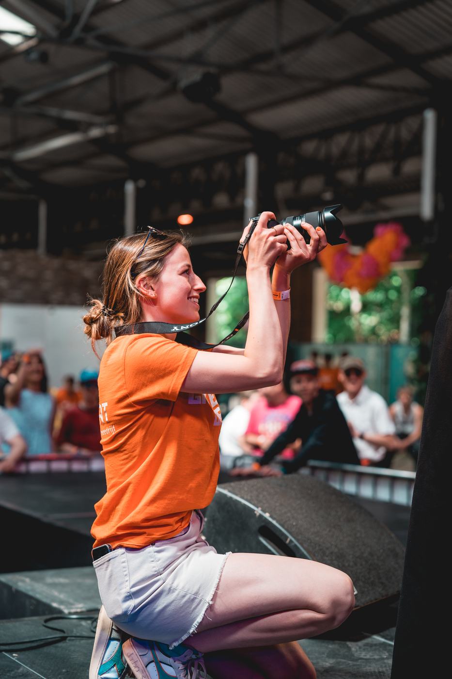 Een vrijwilliger fotografeert het publiek vanaf het podium.